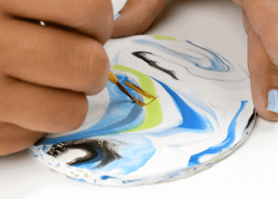 Painting a monogram on a coaster.