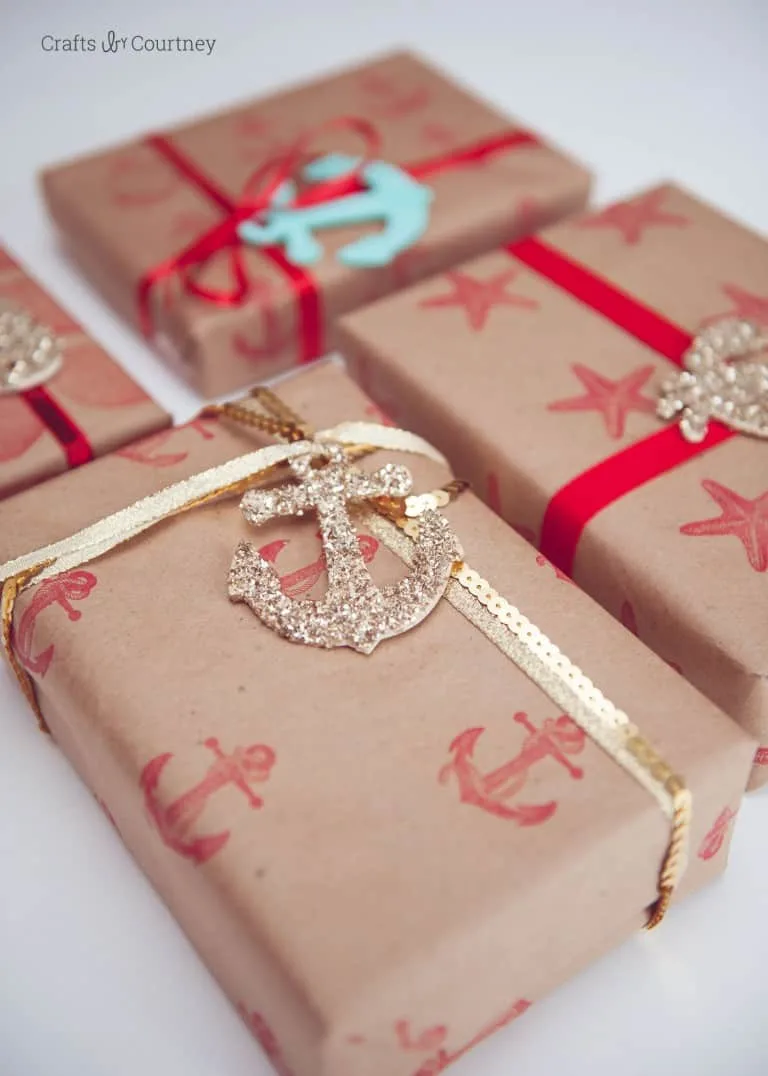 Gifts wrapped in DIY stamped wrapping paper with nautical theme and gold ribbon.